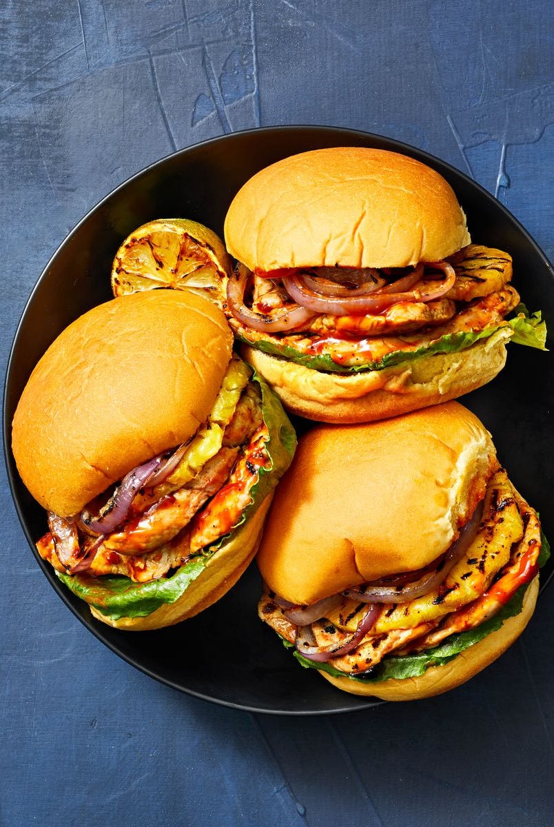 grilled pork pineapple burgers on a black plate
