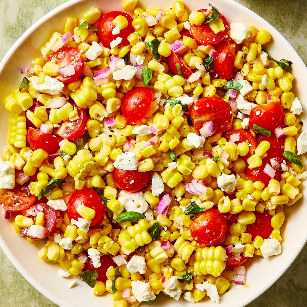 Corn Salad corn, chopped tomatoes, feta and basil in a bowl