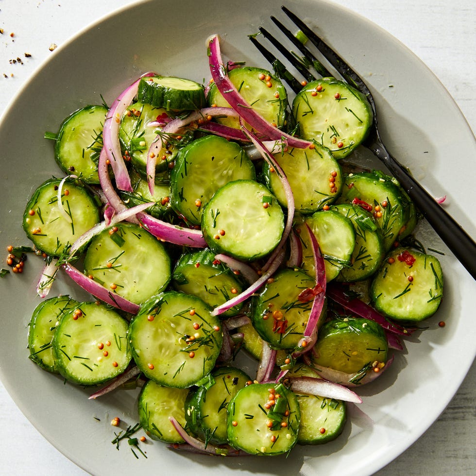 Cucumber Salad cucumber salad with red onions, mustard seeds, with a fork in a bowl