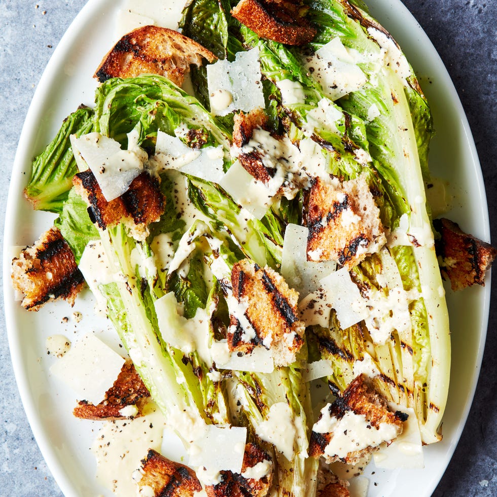 Grilled Romaine Lettuce Wedge grilled romaine lettuce wedge topped with caesar dressing and croutons on a white platter