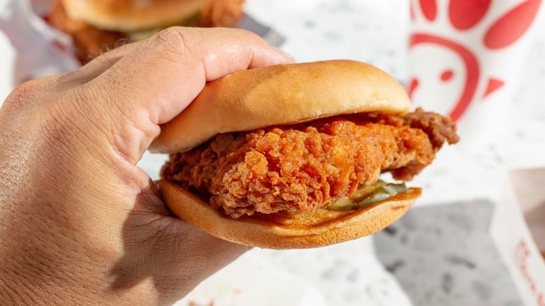 Hand holding Chick-fil-A chicken sandwich