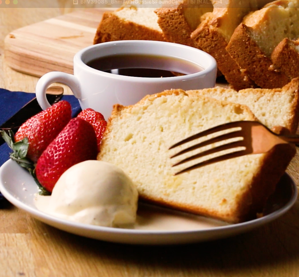 Cake slices with strawberries, a scoop of ice cream, and a cup of coffee on a table