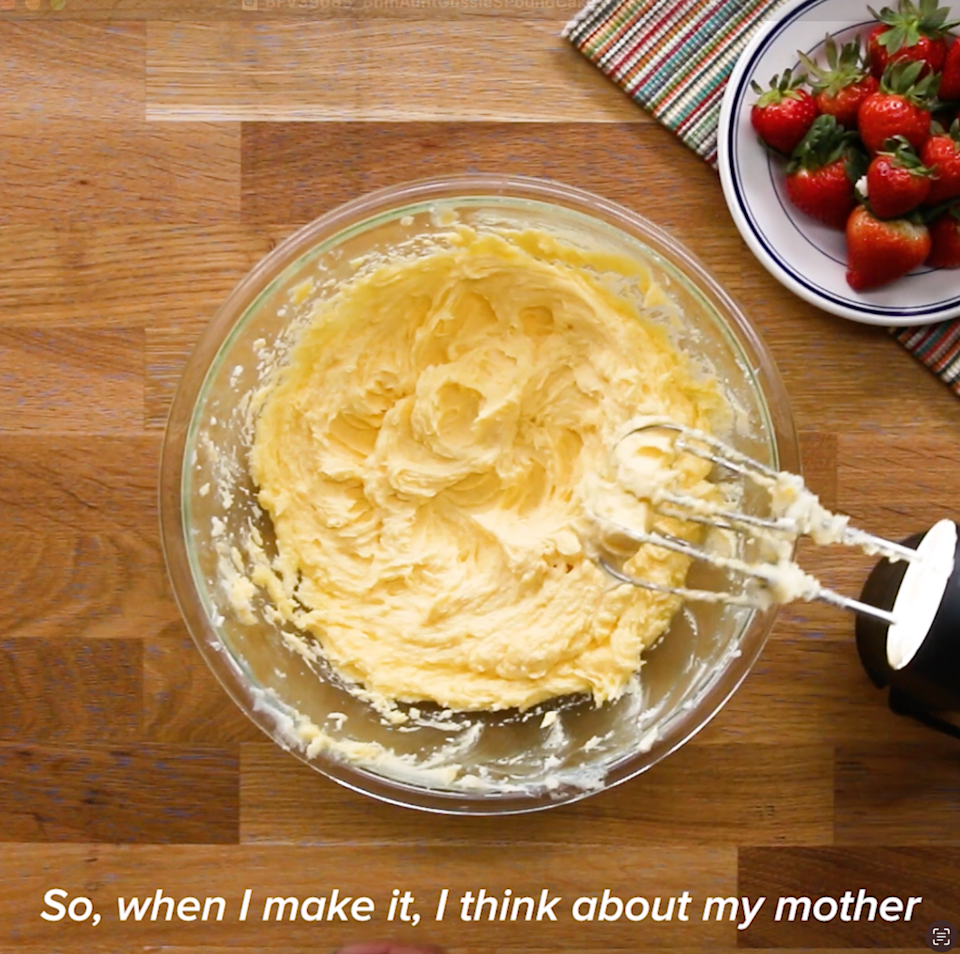 Bowl of creamy batter with an electric mixer, next to a plate of strawberries. Text reads: "So, when I make it, I think about my mother."