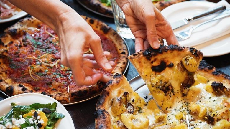 Pulling a slice from Gjelina's pizza