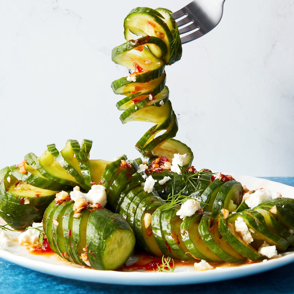 Viral spiral cucumber salad fork lifting a spiral of viral spiral cucumber salad dressed with harissa and feta