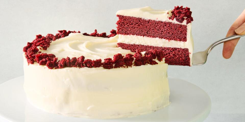 layered red velvet cake with cream cheese icing and pieces of cake