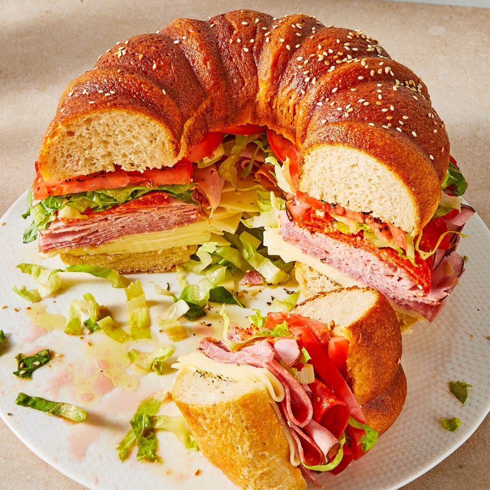 Giant Party Sub bundt cake bread filled with sliced salami, ham, provolone, tomatoes, lettuce, and pepperoni