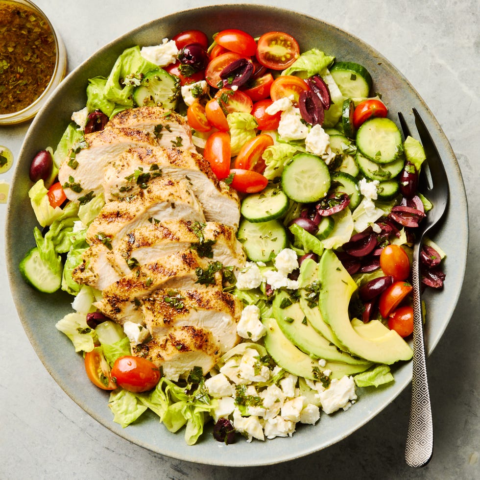 Grilled Chicken Salad salad topped with sliced grilled chicken, cucumbers, cherry tomatoes, olives, and feta