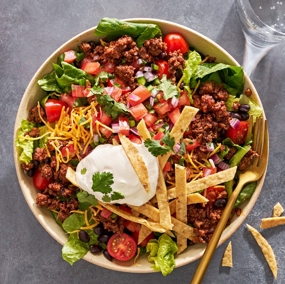 Taco Salad taco salad with sour cream, tomatoes, ground beef, and tortilla strips