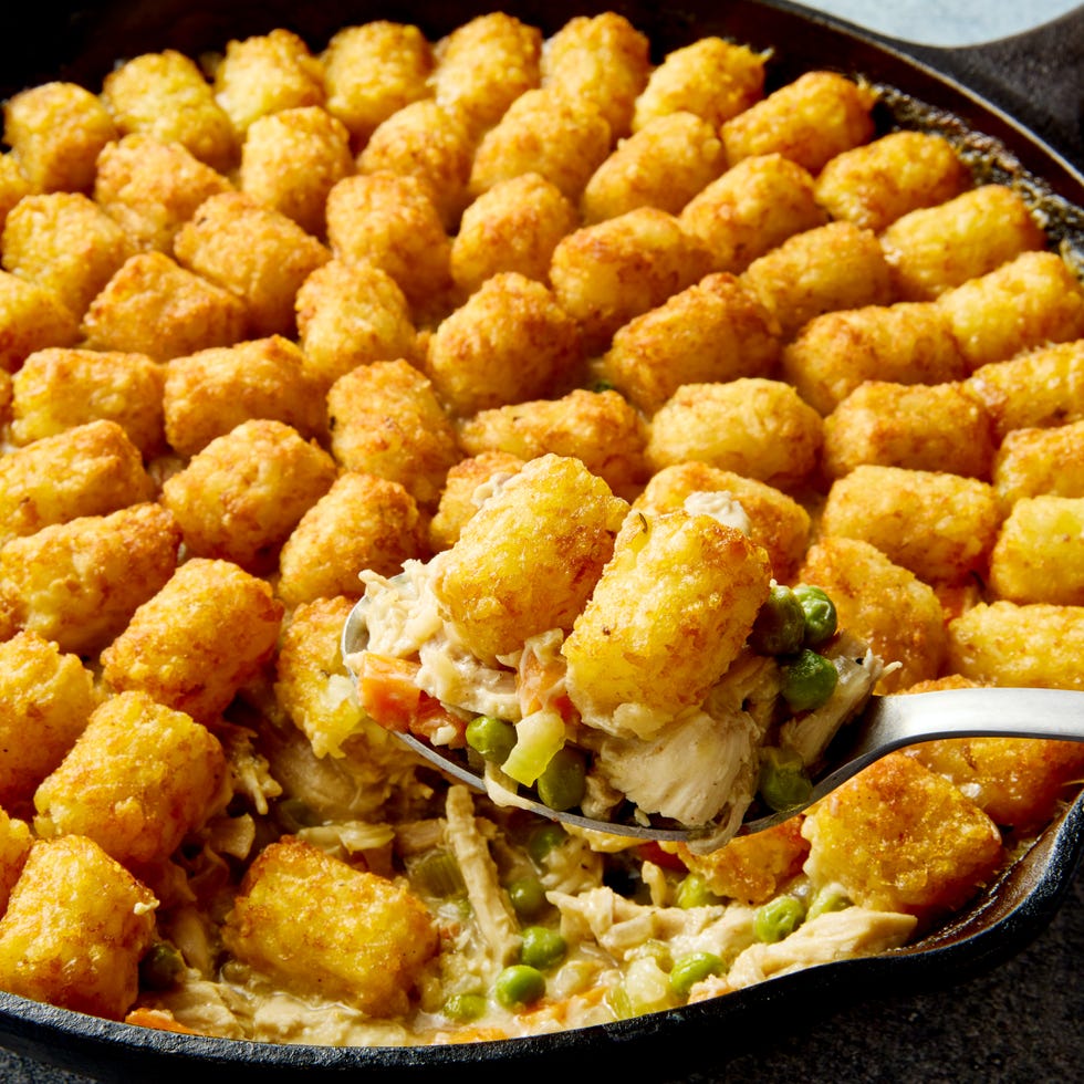 Tater Tot Chicken Pot Pie chicken pot pie filling in a skillet topped with tater tots