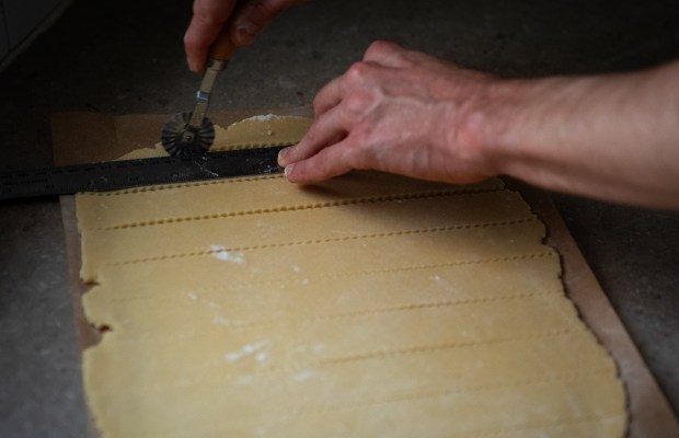 Pastry dough is cut with a pizza cutter for the apricot and Rainier cherry Crostata. (E. Jason Wambsgans/Chicago Tribune)