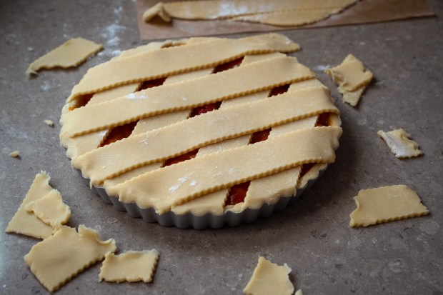 Excess dough is cug away after topping the apricot and Rainier cherry Crostata. (E. Jason Wambsgans/Chicago Tribune)