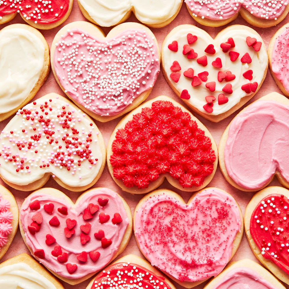 heart shaped sugar cookies iced with red, white, and pink frosting and sprinkles