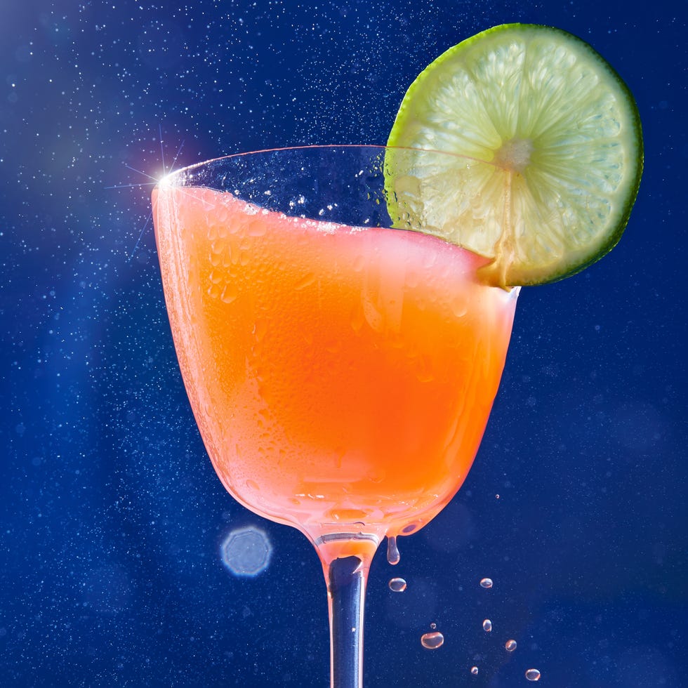 naked and famous cocktail in a glass with a lime wheel