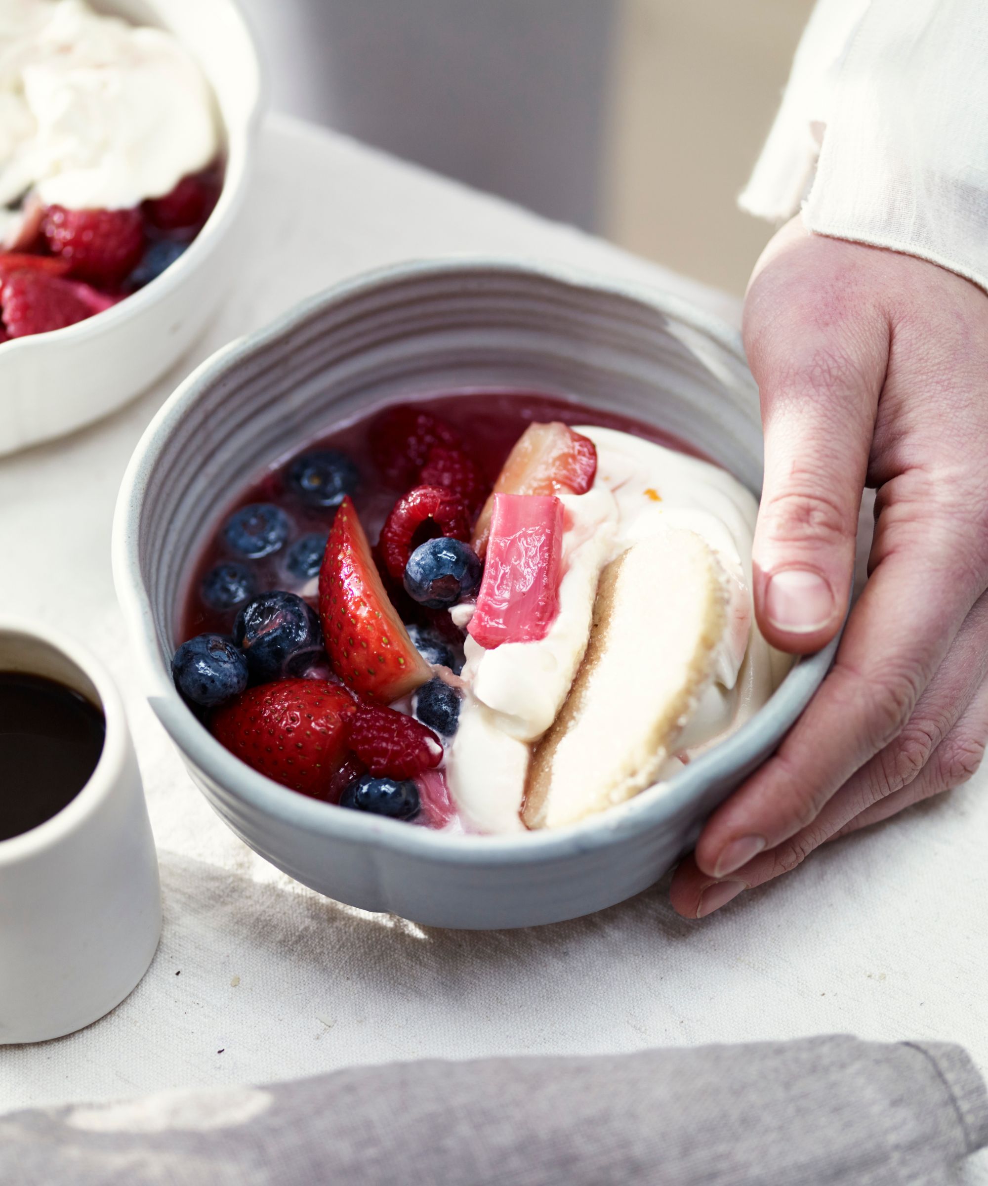 Cream ceramic bowl filled with berries, fruit compote and syllabub