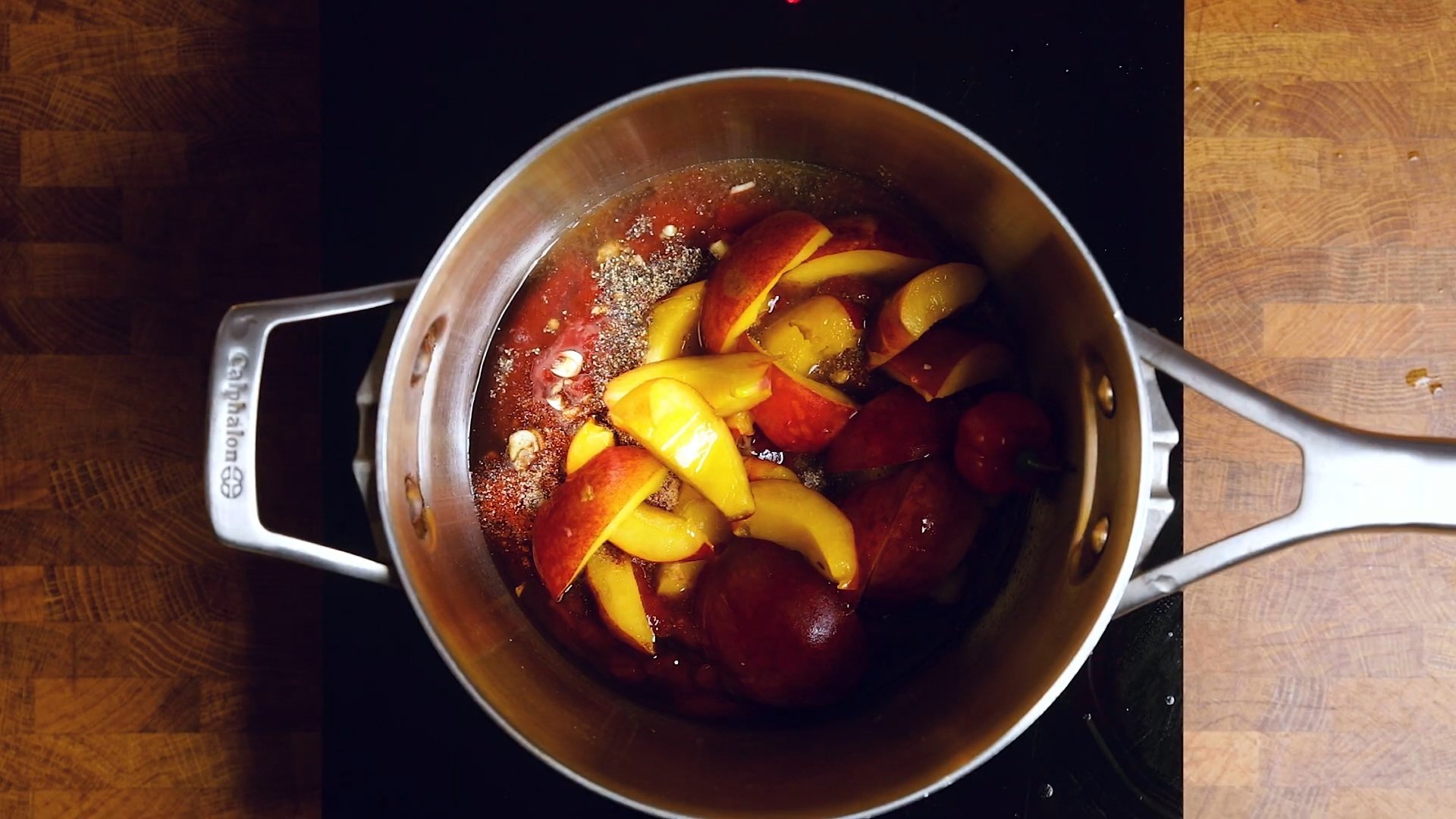 A shot of the peach habanero sauce, one of three vegan BBQ sauces, from above, as it simmers in a steel pot