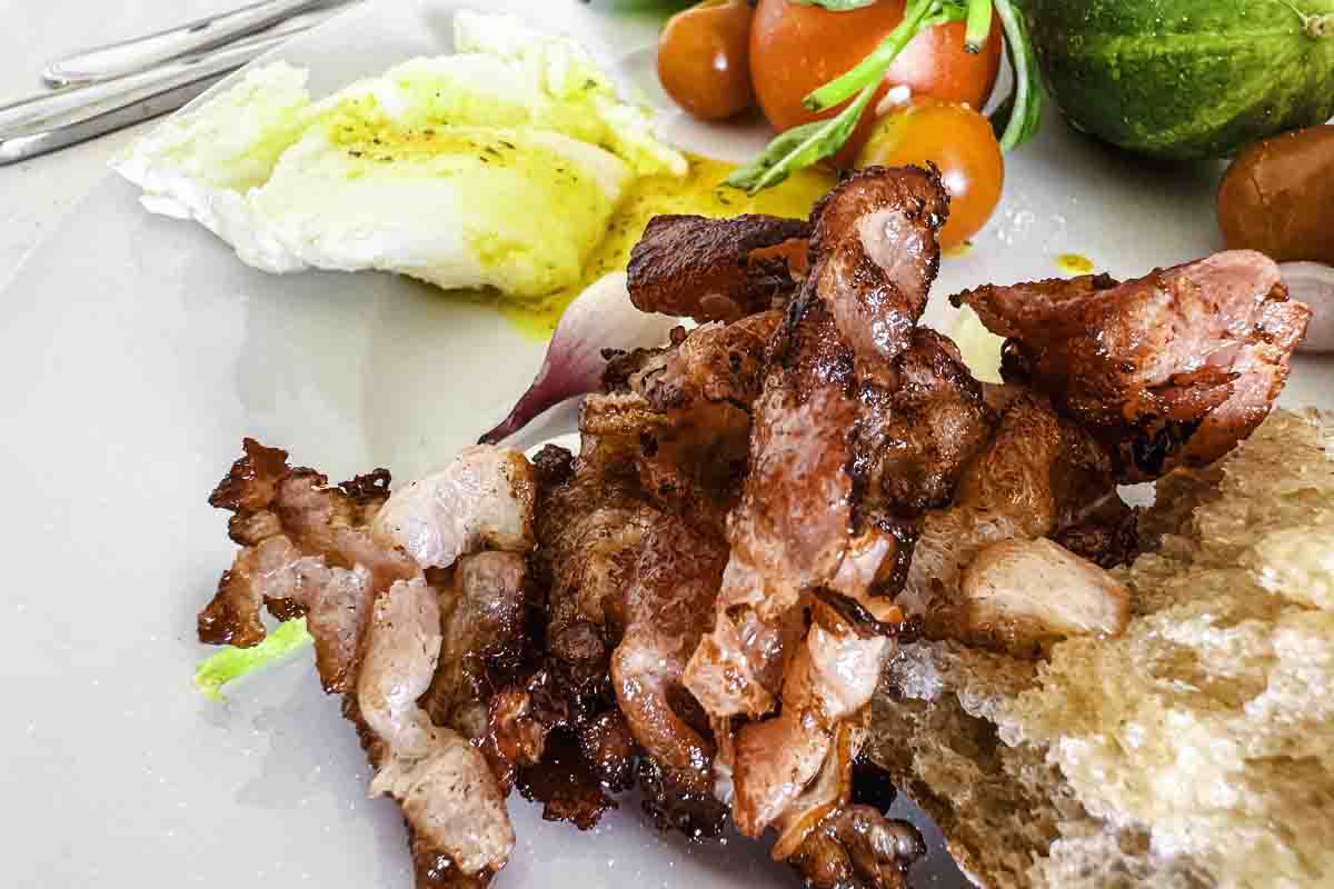 A plate of crispy bacon with bread and eggs.
