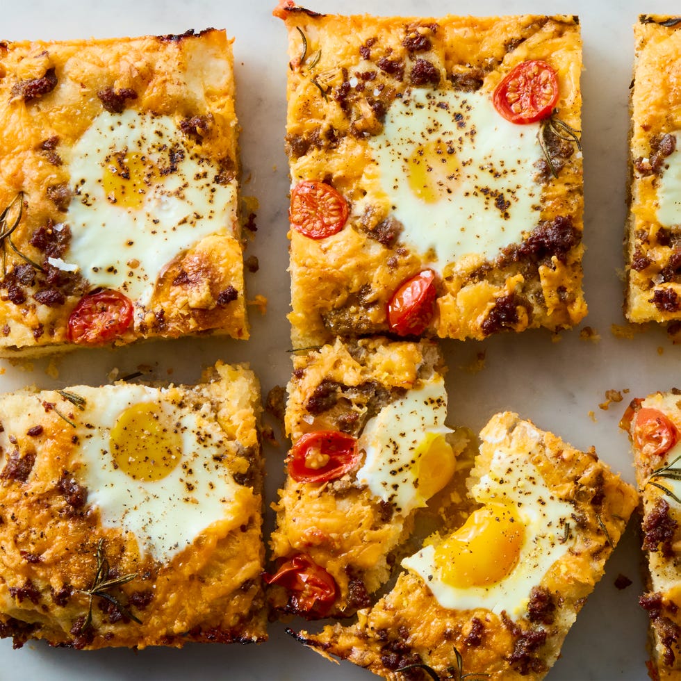 Breakfast Focaccia classic focaccia reimagined into the ultimate breakfast with crispy edges, layers of crumbled breakfast sausage, shredded cheese, and juicy cherry tomato and jammy eggs.