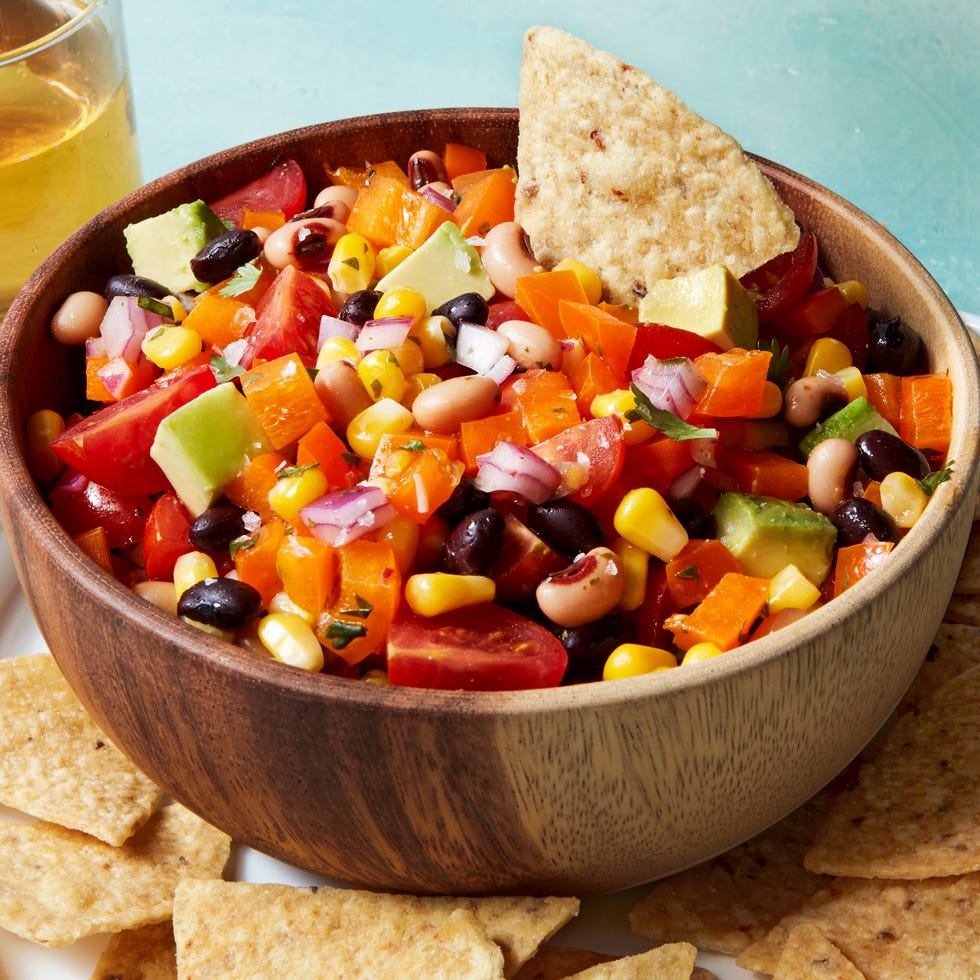 Cowboy Caviar beans, tomatoes, red onion, and avocado in a bowl with chips