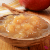 a small wooden bowl of homemade applesauce made in the crockpot