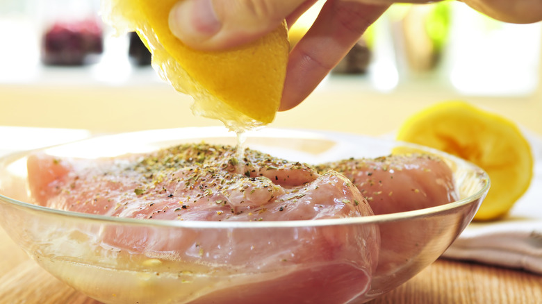 squeezing lemon into chicken marinade