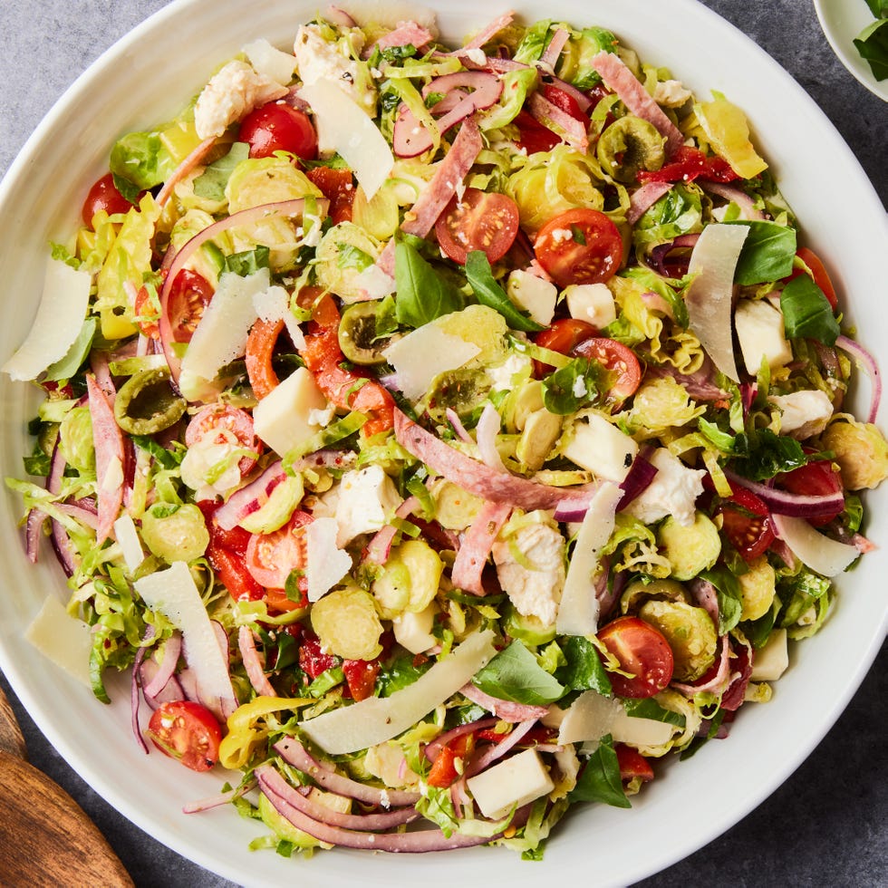Italian Chopped Brussels Sprouts Salad brussels sprouts salad with olives, tomatoes, red onions, shaved parmesan, and salami