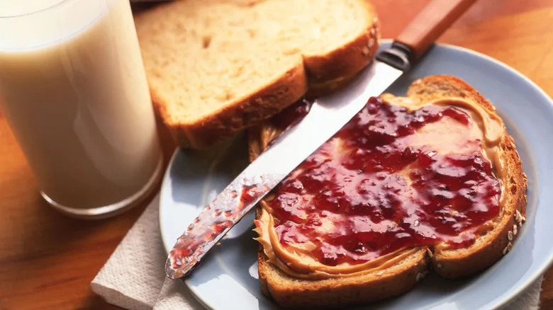 Peanut butter and jelly sandwich with glass of milk