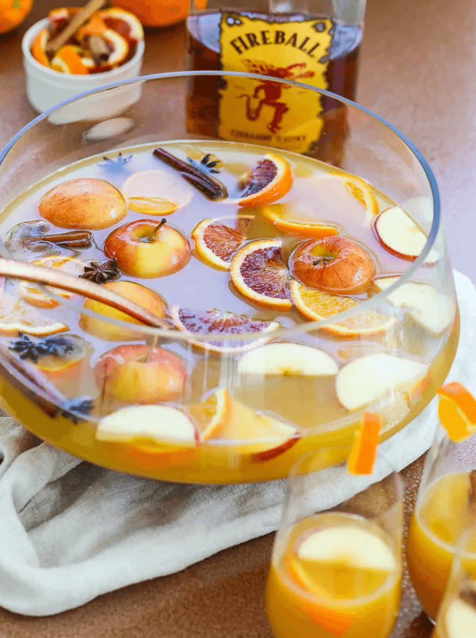 large punch bowl with apples, citrus, and cinnamon