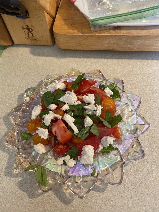 plate of fresh tomatoes with basil and mozzarella