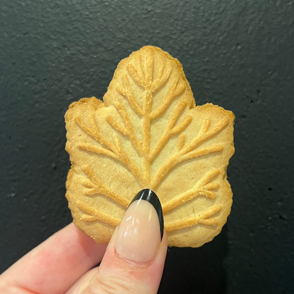 hand holding maple leaf shaped cookie