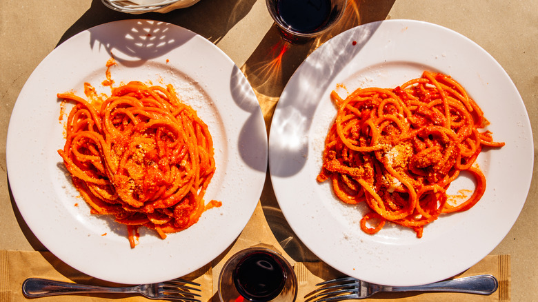 Two plates of spaghetti with tomato sauce