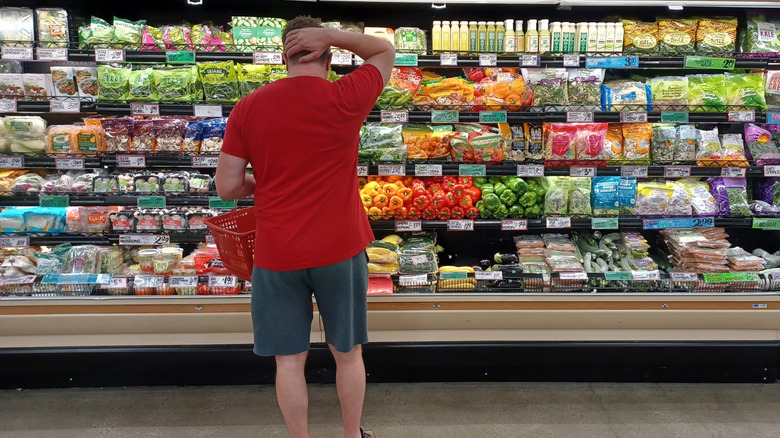 man in a Trader Joe's looking at refrigerated section