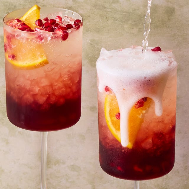 bubbly cocktail with pomegranate seeds and an orange slice