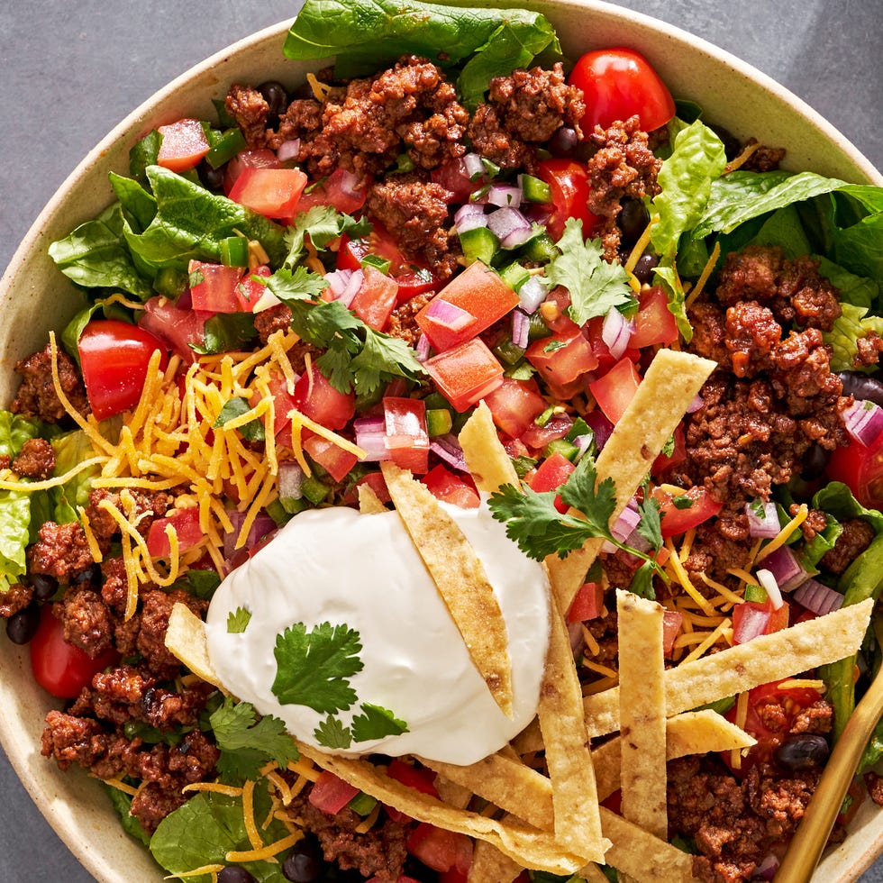 Taco Salad taco salad with sour cream, tomatoes, ground beef, and tortilla strips
