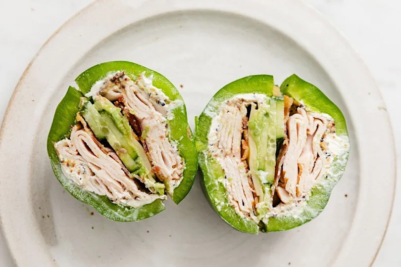 Bell pepper sandwich cut in half on a plate.
