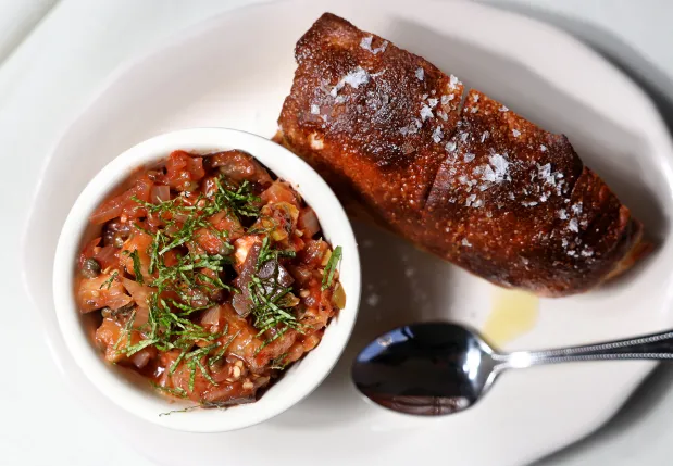 The caponata, an intensely flavorful roasted eggplant variation of the Sicilian agrodolce dish, comes with that stunning focaccia on the side at Pizz'amici, Sept. 25, 2025. (Chris Sweda/Chicago Tribune)