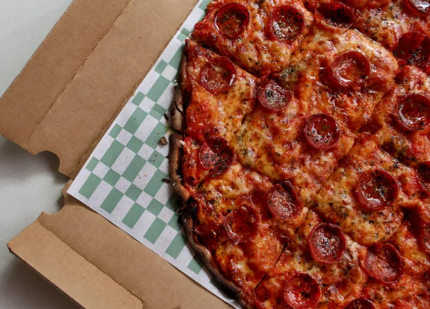 Pepperoni and Mike's hot honey drizzle pizza in a takeout box at Pizz'amici, Sept. 25, 2025. (Chris Sweda/Chicago Tribune)