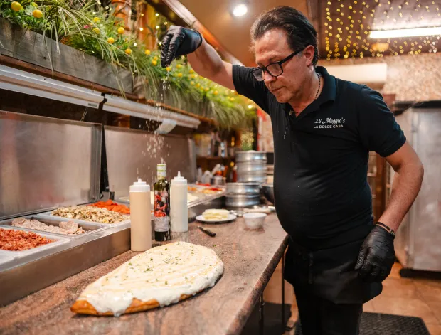 Owner Alfi Picone garnishes a German stromboli at La Dolce...