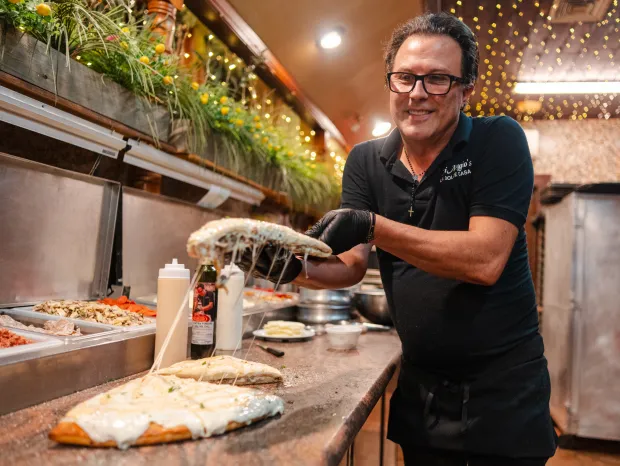 Owner Alfi Picone shows off a slice of a German...