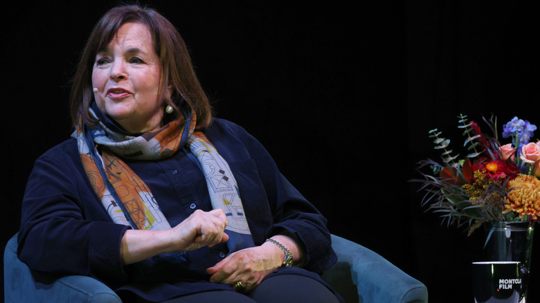 Ina Garten wears a tiny microphone and sits on a stage as part of a panel