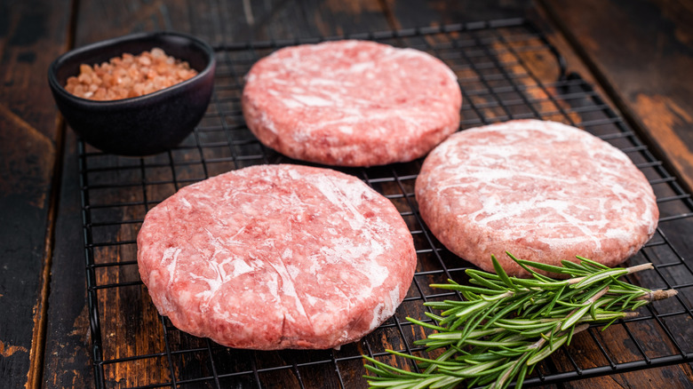 Frozen burger patties on a wire rack