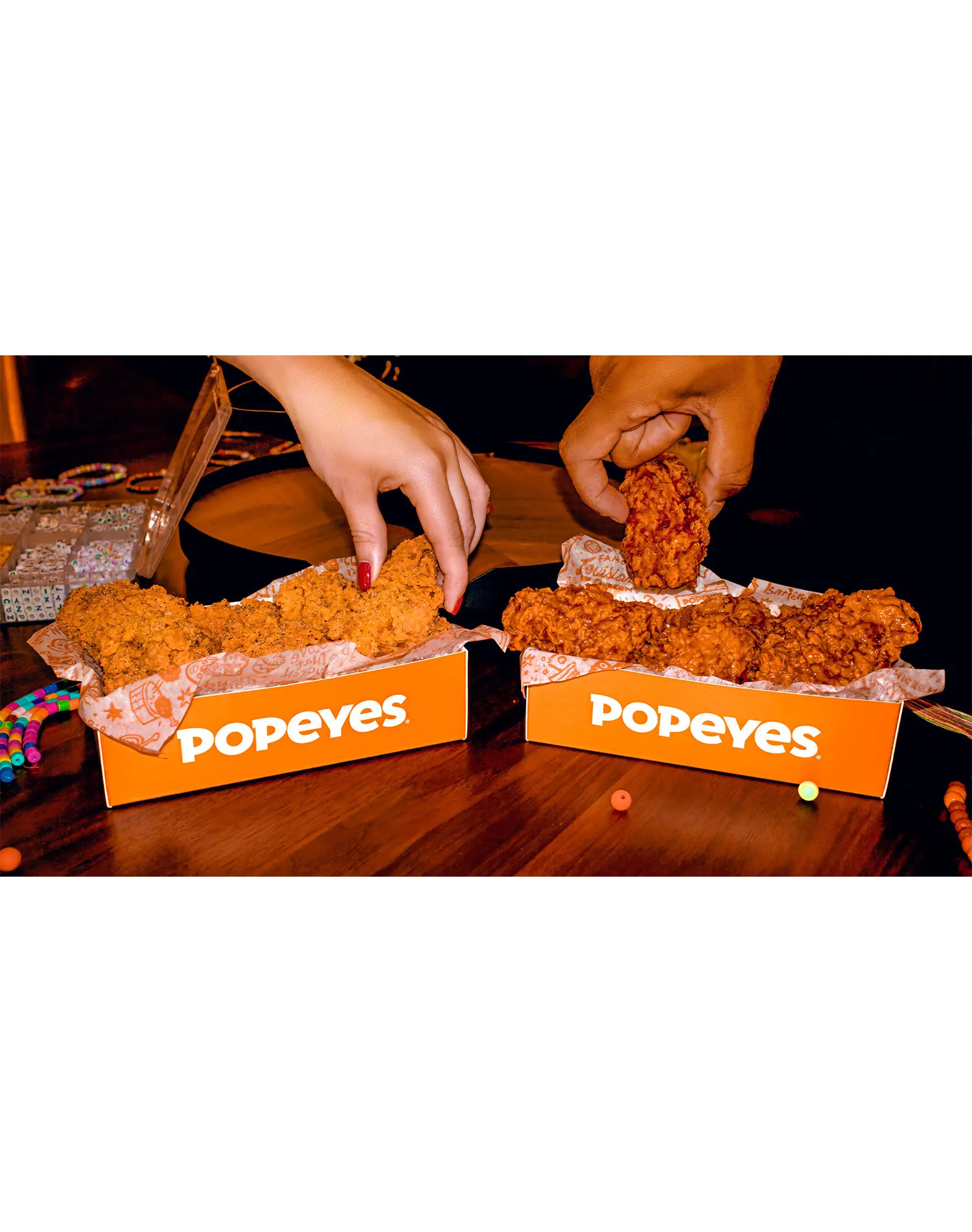 popeye's bone-in chicken wings review: hands picking up popeye's bone-in chicken wings out of popeye's boxes